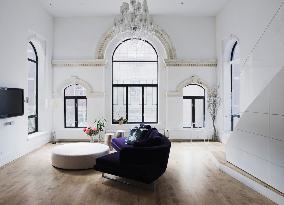 Идея дизайна: открытая гостиная комната в викторианском стиле с белыми стенами, светлым паркетным полом и телевизором на стене