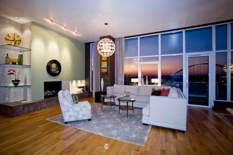 Imagen de salón abierto contemporáneo de tamaño medio sin televisor con paredes verdes, todas las chimeneas y suelo de madera en tonos medios