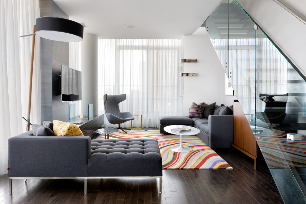 Immagine di un soggiorno contemporaneo con pareti bianche, parquet scuro e TV a parete