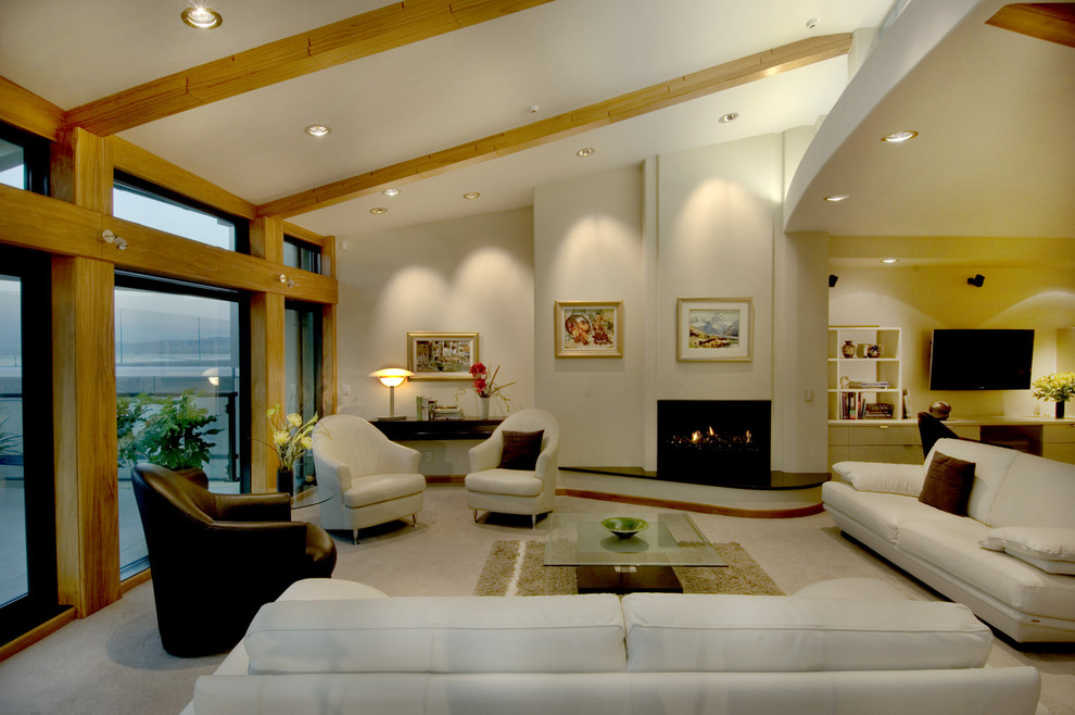 На фото: открытая гостиная комната в современном стиле с стандартным камином с