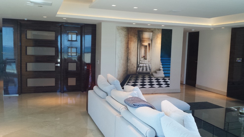 Diseño de salón abierto actual grande con paredes beige, suelo de mármol y televisor colgado en la pared