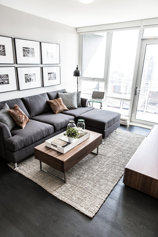 Mittelgroßes, Repräsentatives Modernes Wohnzimmer mit dunklem Holzboden, TV-Wand, grauer Wandfarbe und braunem Boden in Vancouver
