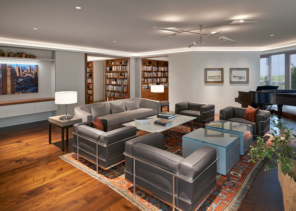 Photo of a large contemporary formal open plan living room in DC Metro with dark hardwood flooring, a standard fireplace, a wooden fireplace surround, white walls, no tv and brown floors.