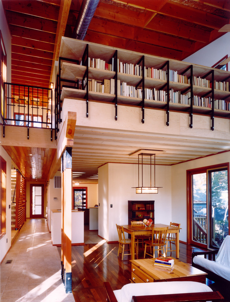 Diseño de biblioteca en casa abierta minimalista de tamaño medio sin televisor con paredes blancas, suelo de madera en tonos medios, todas las chimeneas y marco de chimenea de madera