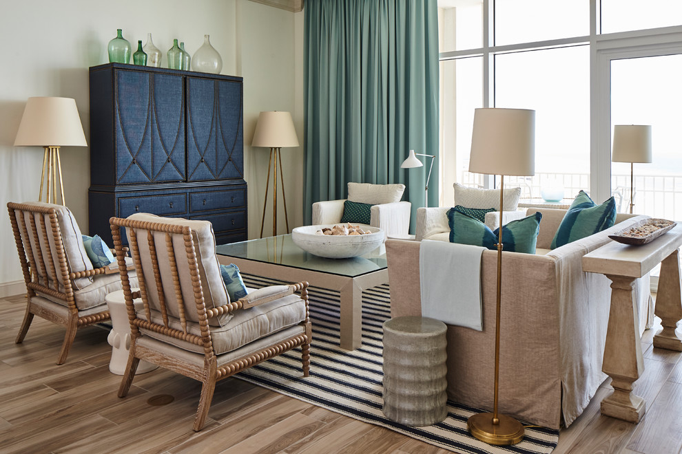 Стильный дизайн: гостиная комната в морском стиле с белыми стенами, скрытым телевизором, бежевым полом и красивыми шторами без камина - последний тренд
