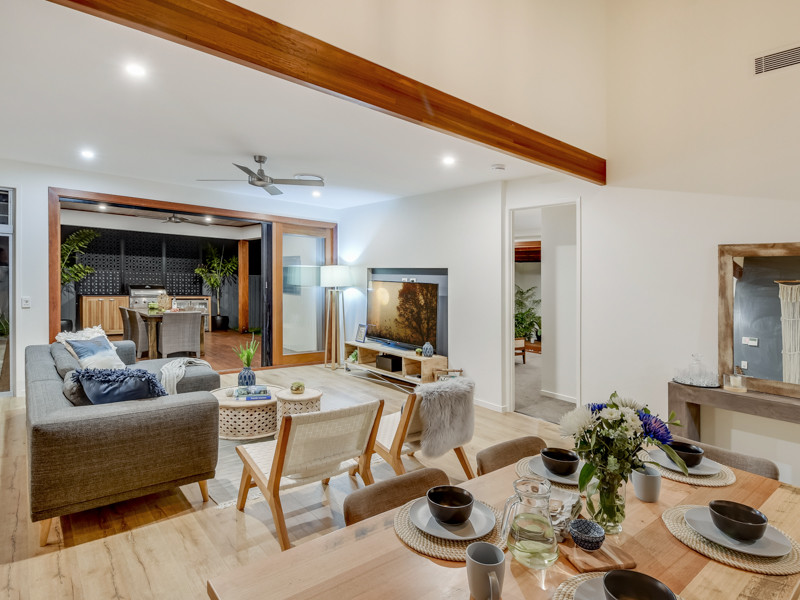 Mittelgroßes, Offenes Modernes Wohnzimmer mit gelber Wandfarbe, Laminat und TV-Wand in Sunshine Coast