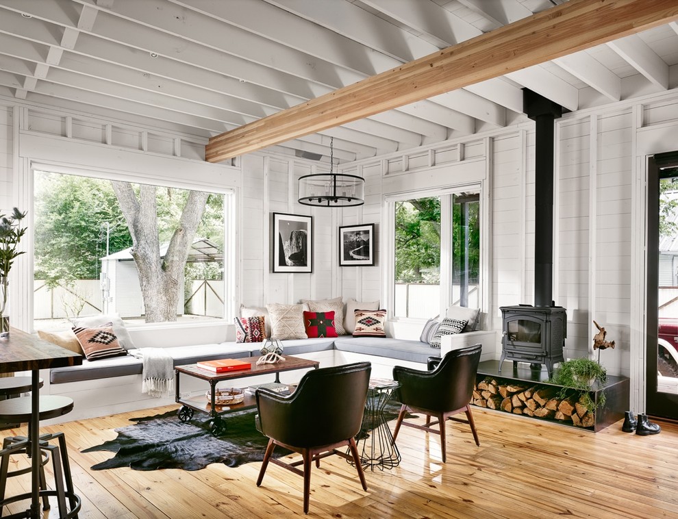 Foto di un piccolo soggiorno country aperto con stufa a legna, pareti bianche e parquet chiaro