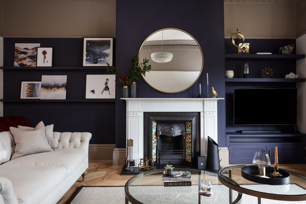 Großes, Repräsentatives, Abgetrenntes Modernes Wohnzimmer mit blauer Wandfarbe, braunem Holzboden, Kamin, gefliester Kaminumrandung, TV-Wand und beigem Boden in Sonstige