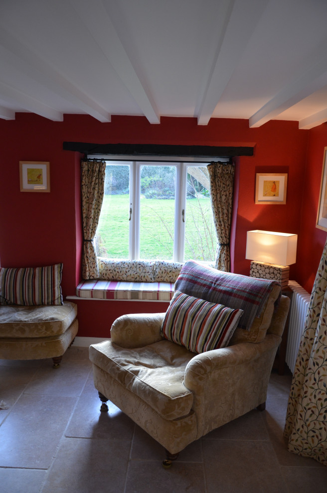 Exempel på ett litet klassiskt separat vardagsrum, med ett bibliotek, röda väggar, kalkstensgolv, en standard öppen spis, en spiselkrans i metall och TV i ett hörn