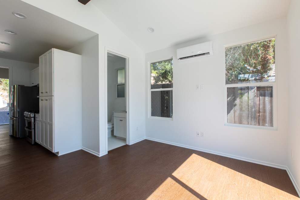 Kleines, Offenes Maritimes Wohnzimmer mit weißer Wandfarbe und freigelegten Dachbalken in San Diego