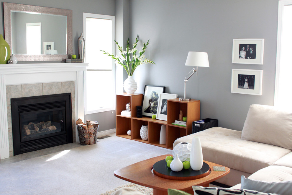 Aménagement d'un salon contemporain avec un mur gris, moquette, une cheminée standard, un manteau de cheminée en carrelage et éclairage.