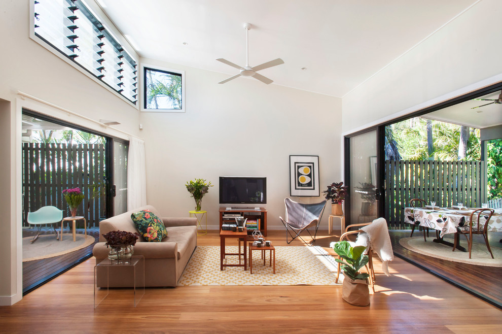 Mittelgroßes, Offenes Modernes Wohnzimmer mit weißer Wandfarbe, braunem Holzboden, TV-Wand und braunem Boden in Brisbane