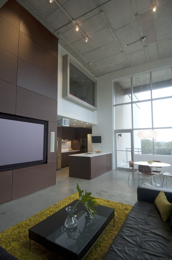 Exempel på ett modernt allrum med öppen planlösning, med betonggolv och en inbyggd mediavägg