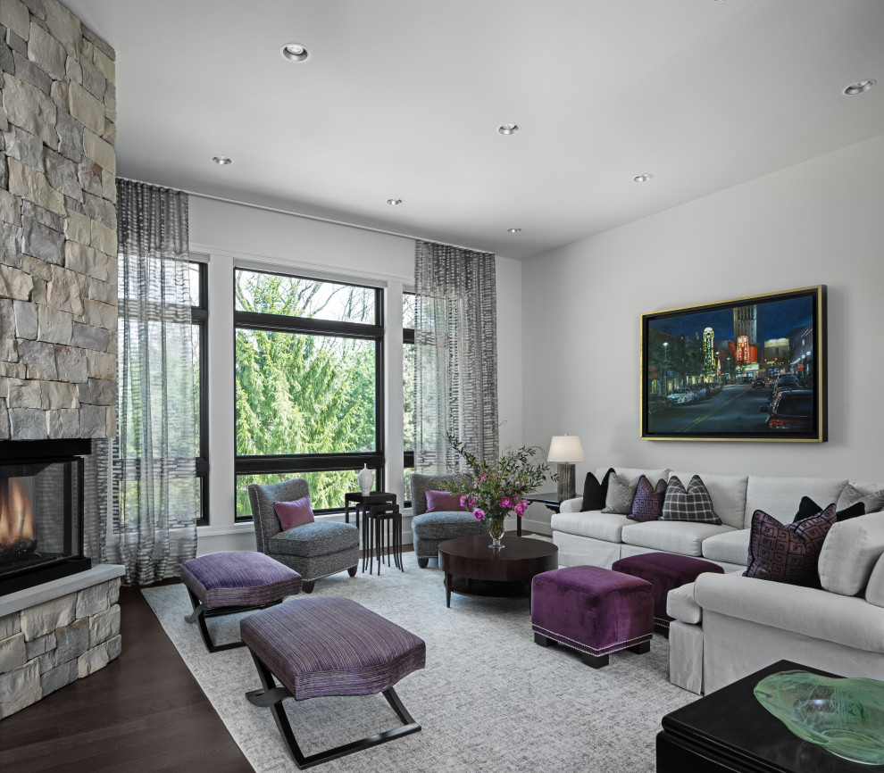 Пример оригинального дизайна: гостиная комната в современном стиле с серыми стенами, темным паркетным полом, угловым камином и фасадом камина из камня