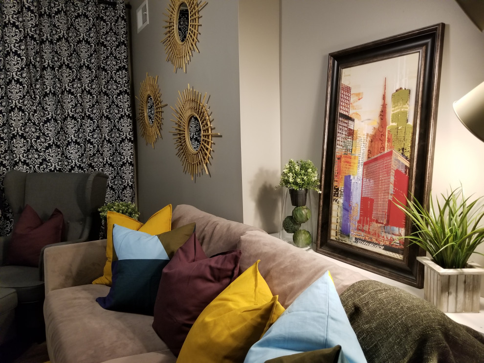 Modelo de salón bohemio con paredes beige, suelo vinílico, televisor colgado en la pared y suelo marrón