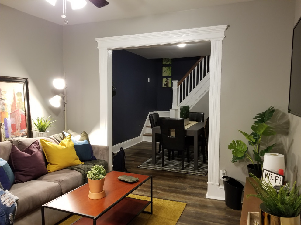 Foto di un soggiorno eclettico con pareti beige, pavimento in vinile, TV a parete e pavimento marrone