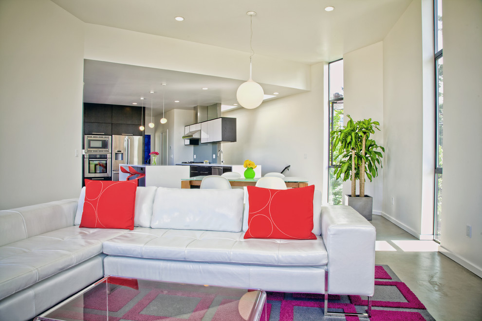 На фото: гостиная комната в современном стиле с белыми стенами и бетонным полом с