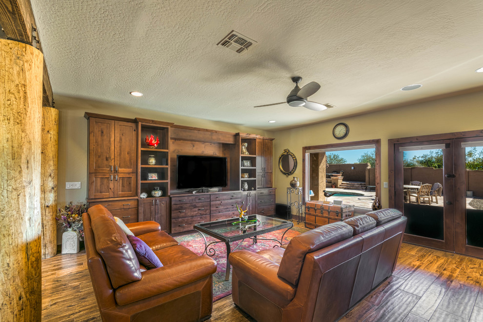 This is an example of a medium sized traditional open plan living room in Phoenix with beige walls, light hardwood flooring and a built-in media unit.