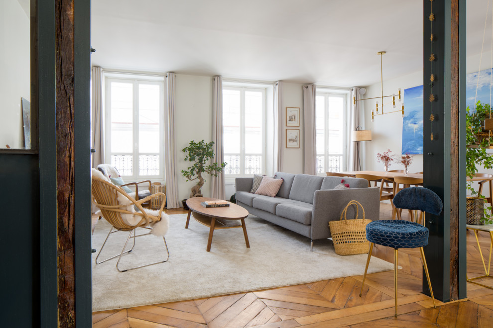 Offenes Modernes Wohnzimmer mit weißer Wandfarbe, braunem Holzboden und braunem Boden in Paris