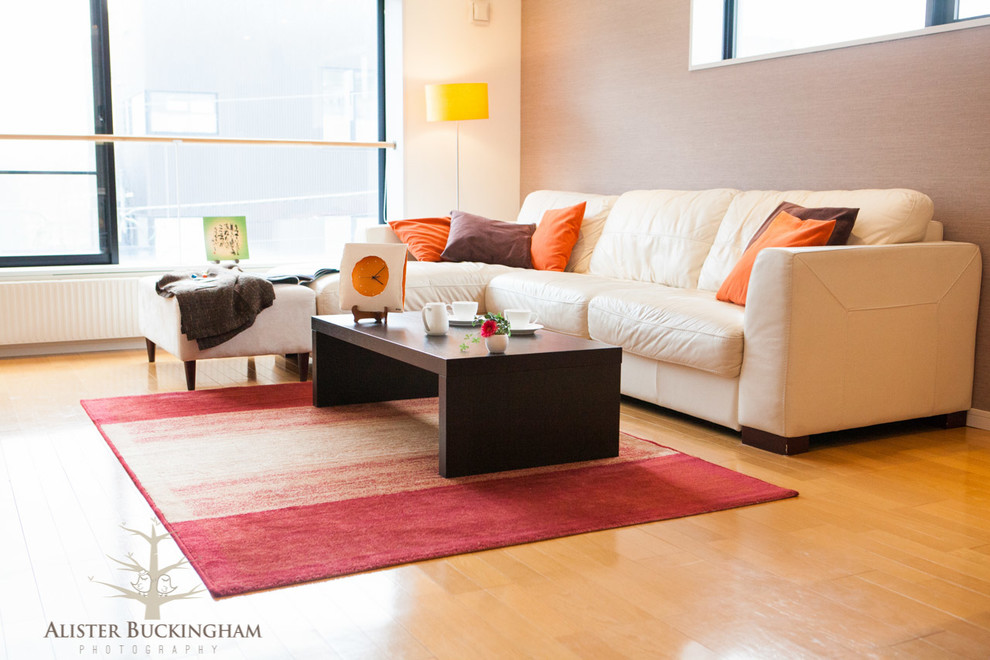 На фото: открытая гостиная комната среднего размера в современном стиле с коричневыми стенами и светлым паркетным полом без камина