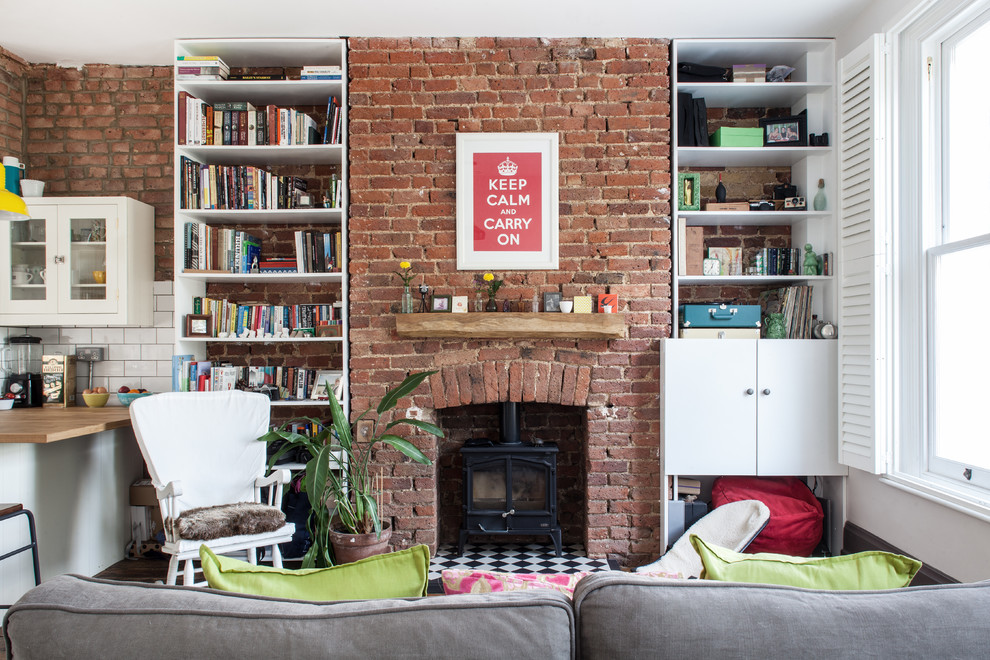Inspiration for a traditional open plan living room in London with white walls, a wood burning stove, a brick fireplace surround, no tv and medium hardwood flooring.