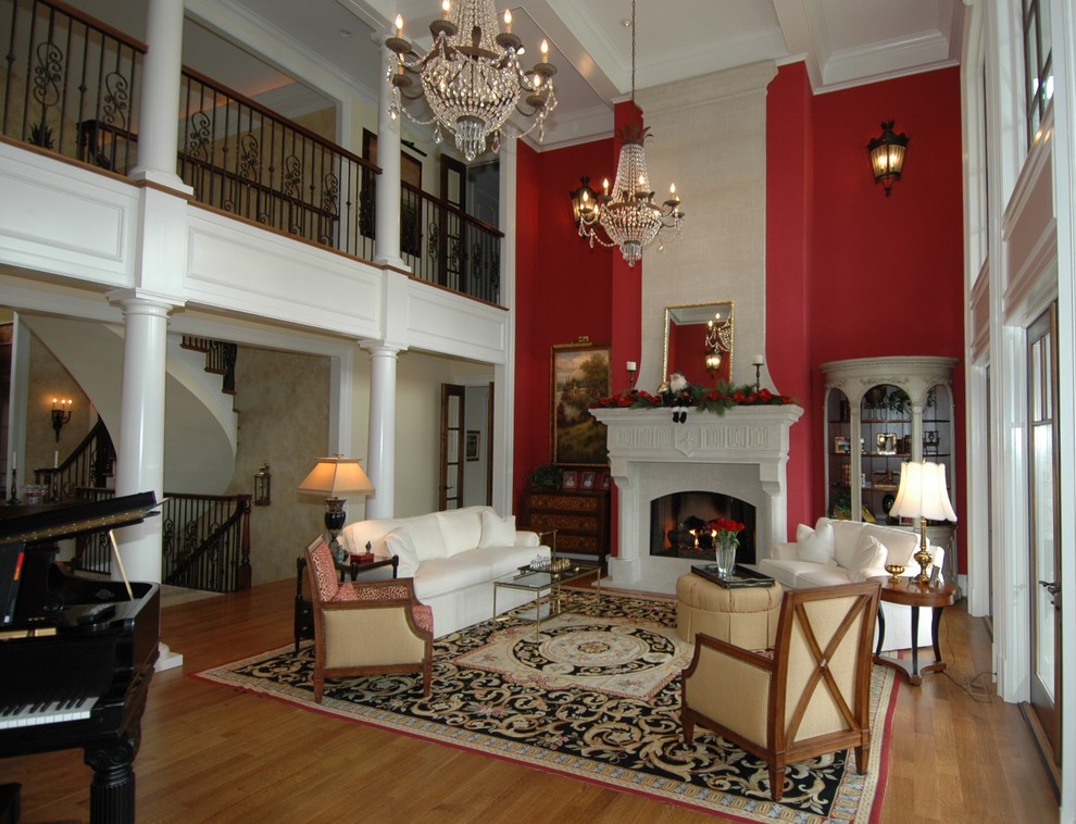 Foto de salón para visitas abierto ecléctico grande con paredes rojas, suelo de madera en tonos medios y marco de chimenea de piedra