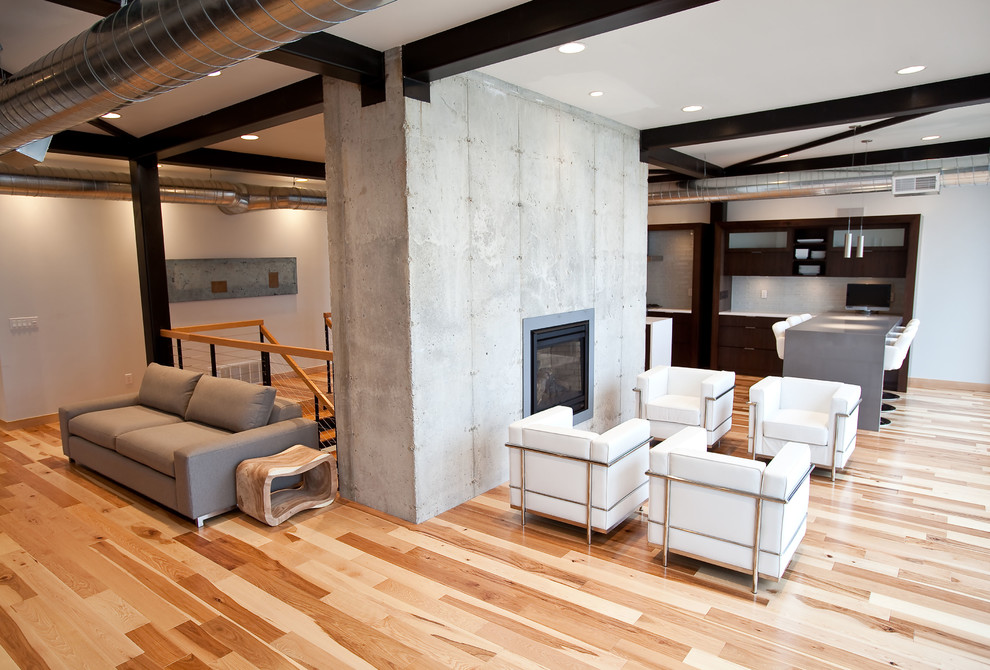 Cette image montre un petit salon minimaliste ouvert avec une salle de réception, un mur gris, parquet clair, une cheminée standard, un manteau de cheminée en métal et aucun téléviseur.