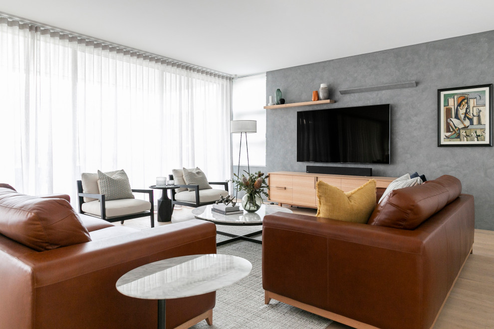 Inspiration pour un grand salon design ouvert avec un mur gris, un téléviseur fixé au mur et un sol beige.