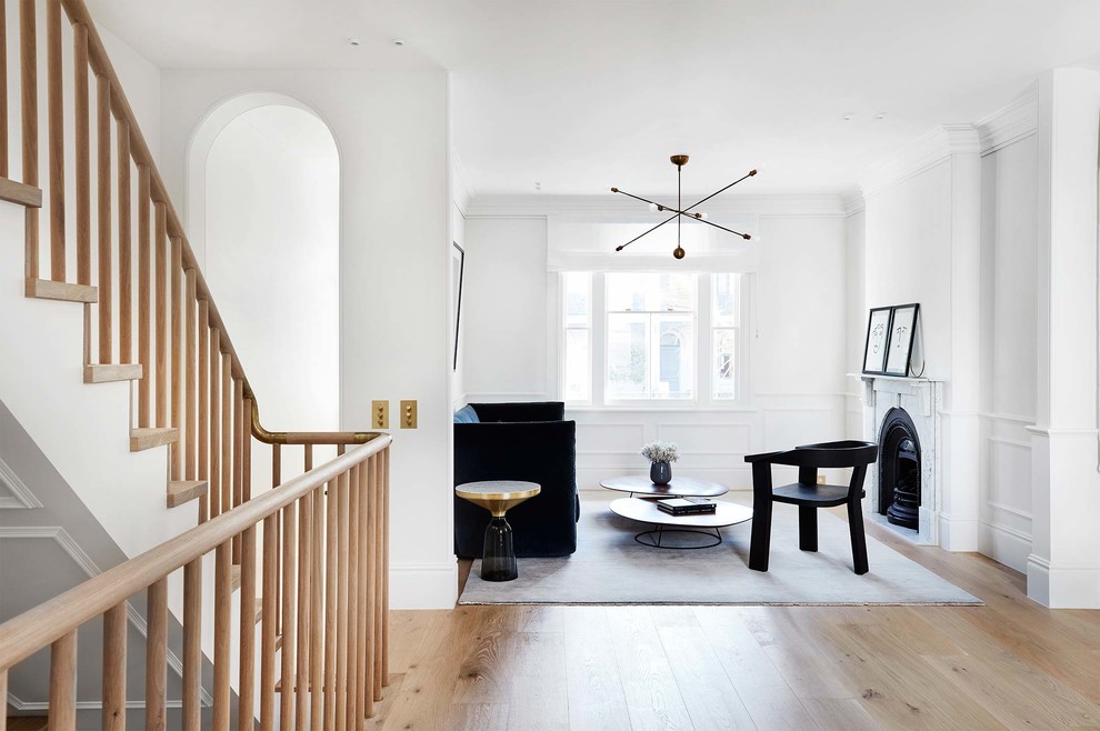 Immagine di un soggiorno scandinavo aperto con pareti bianche, pavimento in legno massello medio, stufa a legna, cornice del camino in metallo e pavimento marrone