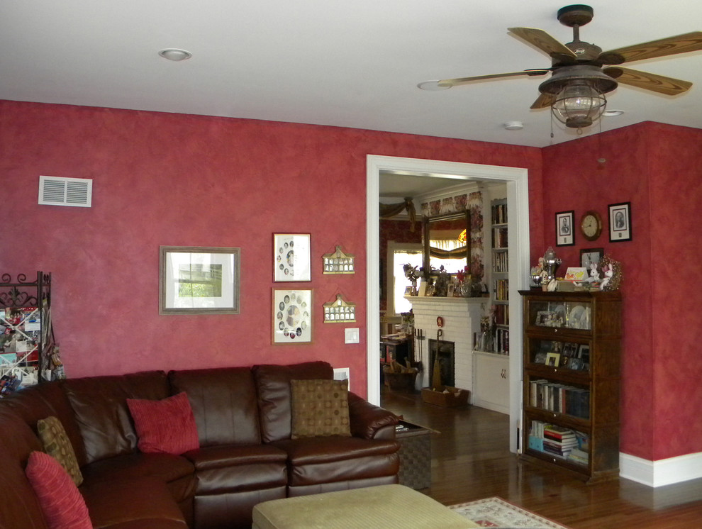 Cette image montre un salon blanc et bois victorien de taille moyenne et ouvert avec un mur rouge, un sol en bois brun, une cheminée standard, un téléviseur fixé au mur, un sol marron, un manteau de cheminée en bois, un plafond en papier peint, du papier peint et une salle de réception.