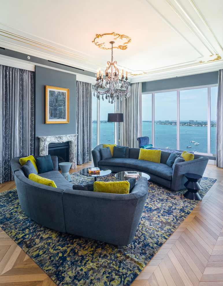Immagine di un soggiorno design con pareti blu, pavimento in legno massello medio, camino classico e pavimento marrone