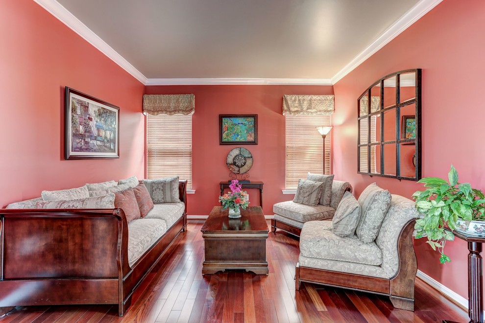 Cette photo montre un petit salon tendance avec un mur rouge et un sol en bois brun.