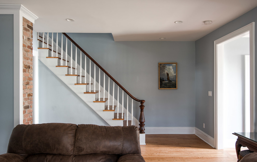 Foto de salón cerrado clásico renovado de tamaño medio sin chimenea y televisor con paredes azules, suelo de madera en tonos medios y suelo marrón