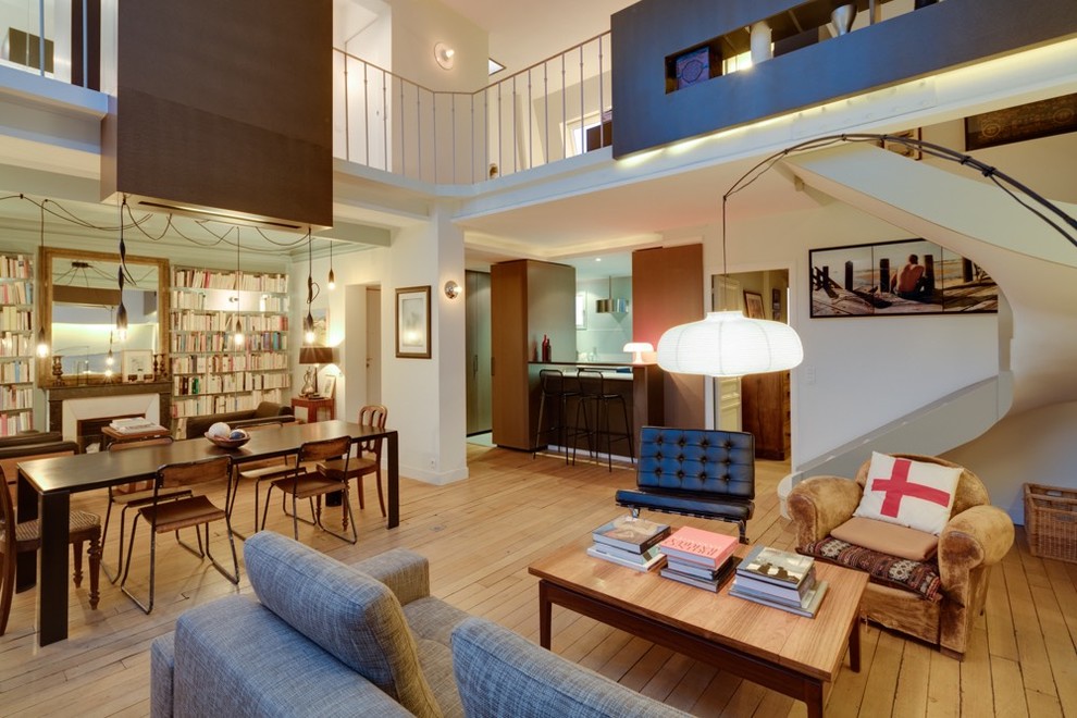 Пример оригинального дизайна: открытая гостиная комната среднего размера в современном стиле с с книжными шкафами и полками, белыми стенами, светлым паркетным полом и стандартным камином без телевизора