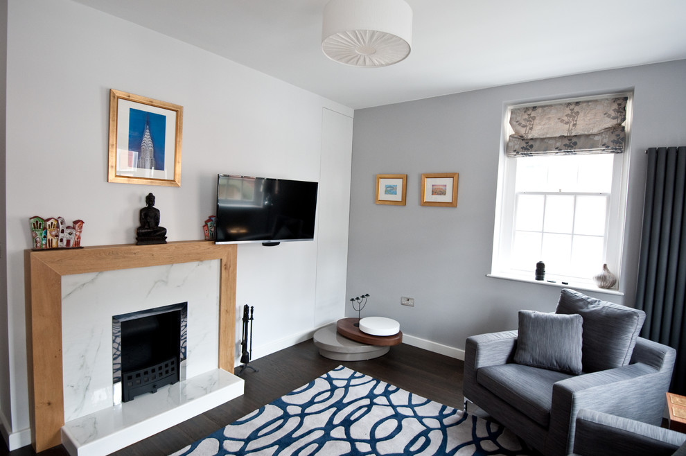 На фото: парадная, изолированная гостиная комната среднего размера в стиле модернизм с серыми стенами, темным паркетным полом, стандартным камином и фасадом камина из дерева с