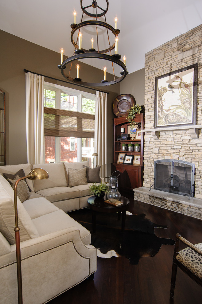 Idée de décoration pour un salon tradition avec un mur marron, parquet foncé, une cheminée standard, un manteau de cheminée en pierre, un téléviseur encastré et un sol marron.