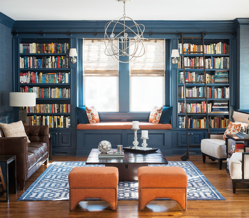 living room and library space with dark blue walls and orange accents