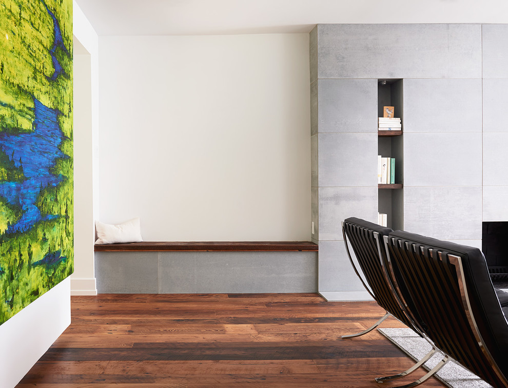Cette image montre un salon minimaliste ouvert et de taille moyenne avec un mur blanc, parquet foncé, cheminée suspendue, un manteau de cheminée en béton, une salle de réception, aucun téléviseur et un sol marron.