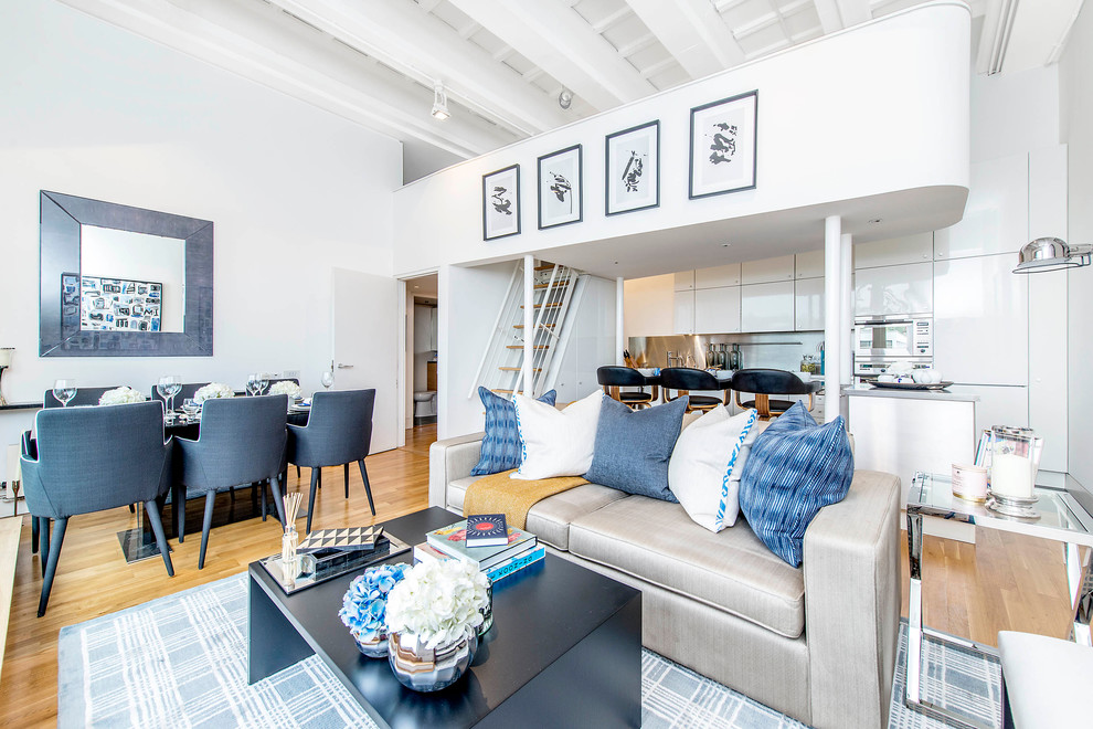 Example of a mid-sized trendy open concept medium tone wood floor living room design in London with no fireplace