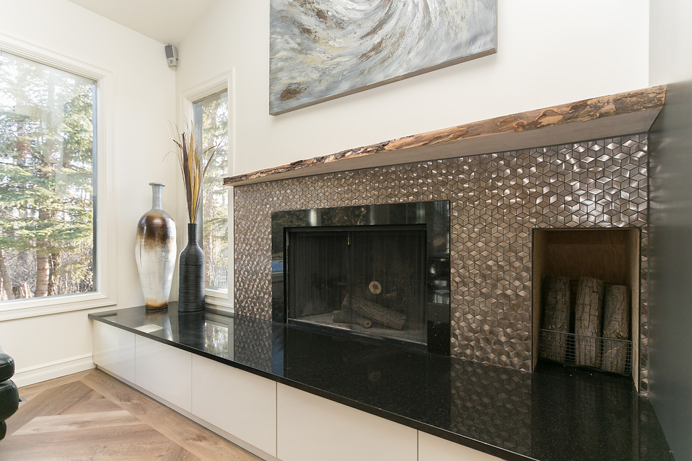 お手頃価格の中くらいなコンテンポラリースタイルのおしゃれなリビング (白い壁、無垢フローリング、標準型暖炉、金属の暖炉まわり、茶色い床) の写真