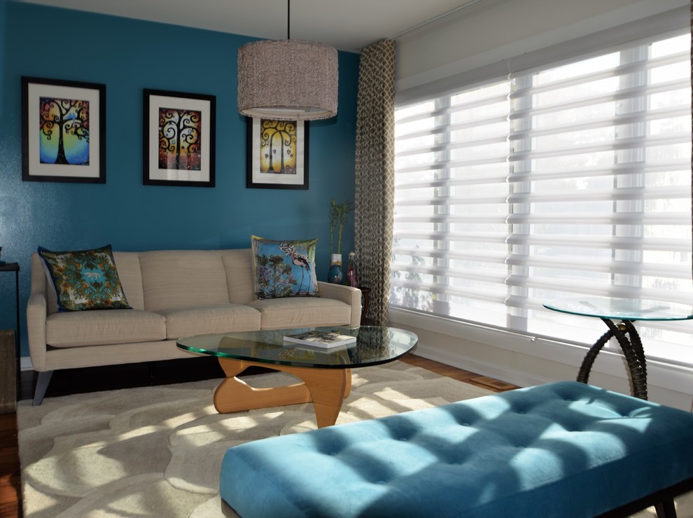 Esempio di un soggiorno moderno di medie dimensioni e aperto con pareti blu, pavimento in legno massello medio, nessun camino e nessuna TV