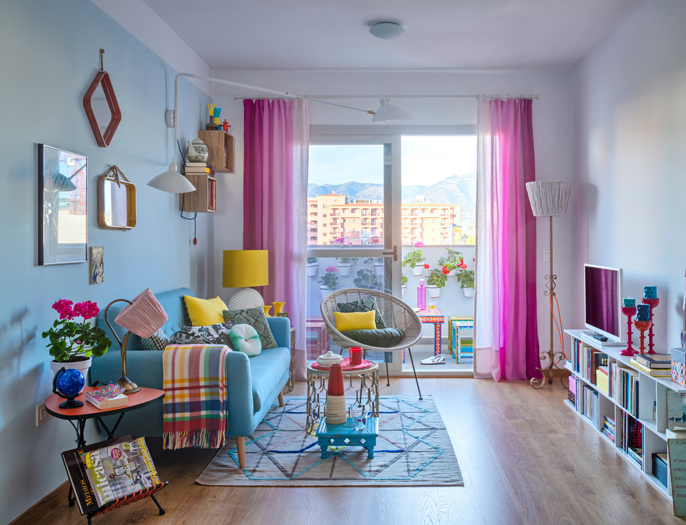 Exempel på ett mellanstort eklektiskt separat vardagsrum, med ett finrum, blå väggar, ljust trägolv och en fristående TV