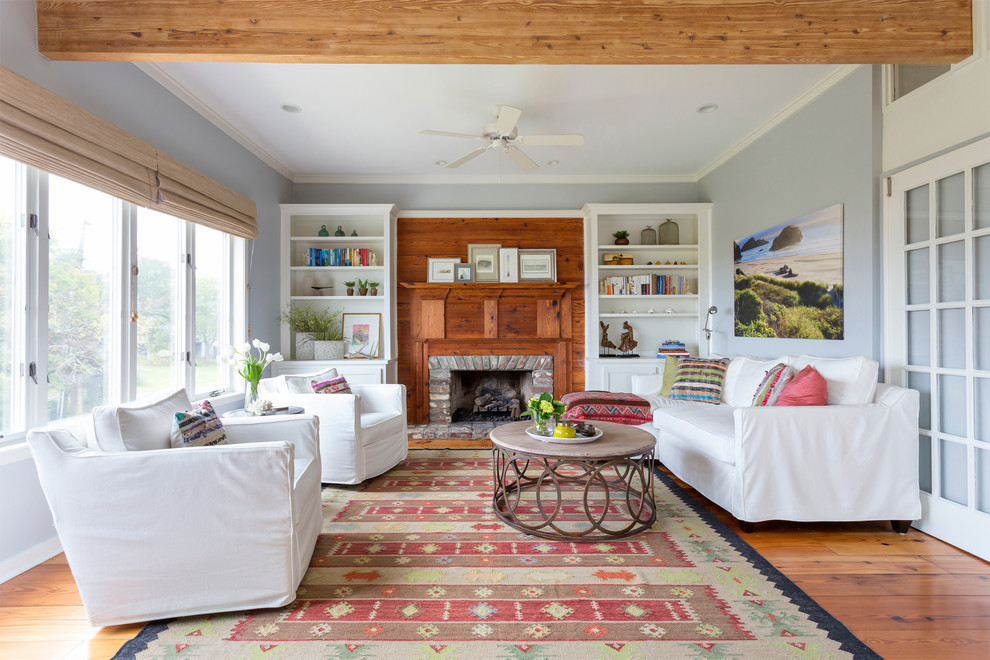Inspiration for a coastal living room remodel in Charleston with blue walls, a standard fireplace and a brick fireplace