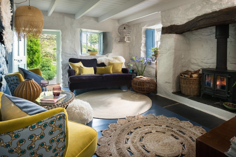 Ispirazione per un piccolo soggiorno bohémian chiuso con pareti bianche, pavimento in linoleum, stufa a legna, cornice del camino in mattoni e pavimento blu
