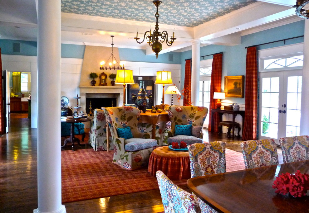 Foto de salón abierto tradicional grande con paredes azules, suelo de madera oscura, todas las chimeneas, marco de chimenea de hormigón y televisor retractable
