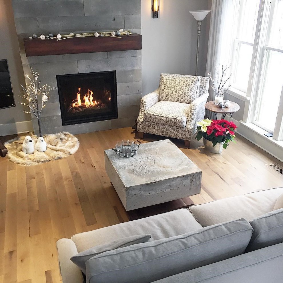Medium sized classic formal enclosed living room in Toronto with grey walls, light hardwood flooring, a standard fireplace, a concrete fireplace surround and no tv.