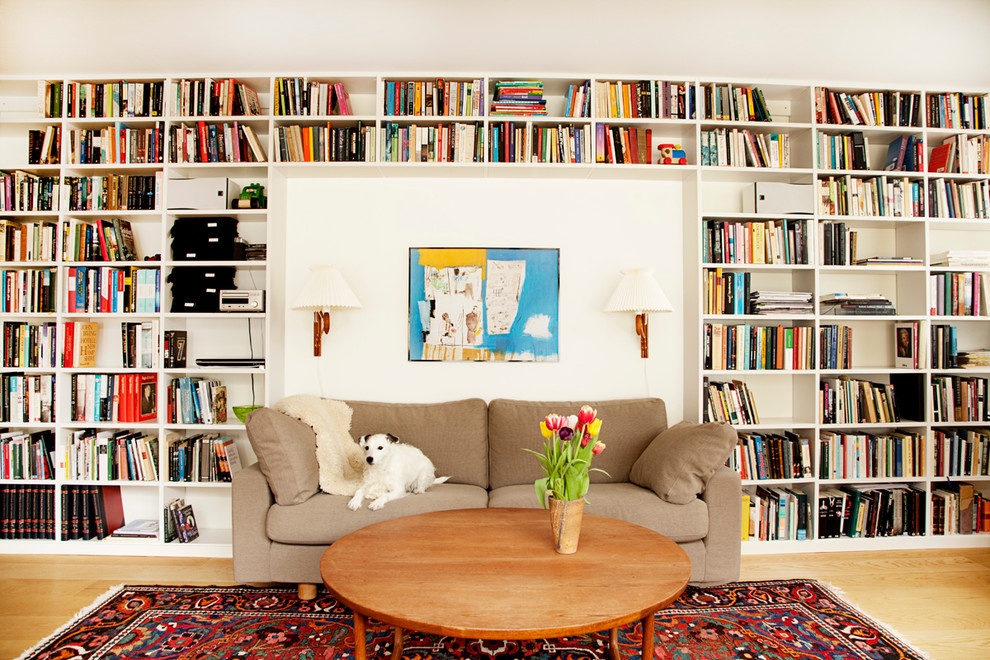 Ejemplo de biblioteca en casa cerrada nórdica de tamaño medio sin chimenea y televisor con paredes blancas y suelo de madera clara