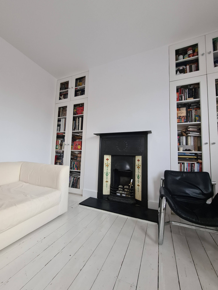 ロンドンにあるお手頃価格の中くらいなトラディショナルスタイルのおしゃれなLDK (ミュージックルーム、白い壁、塗装フローリング、標準型暖炉、金属の暖炉まわり、据え置き型テレビ、白い床、折り上げ天井) の写真