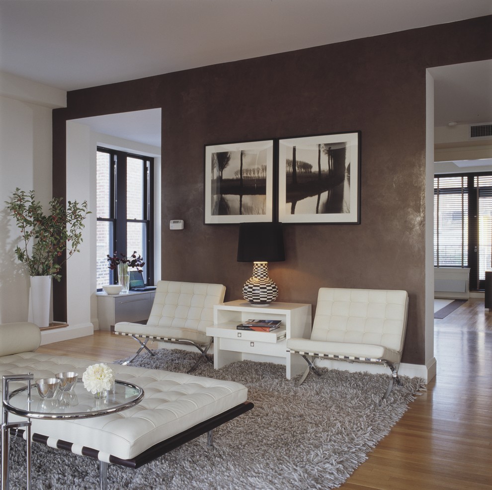 Modernes Wohnzimmer mit brauner Wandfarbe und braunem Holzboden in New York