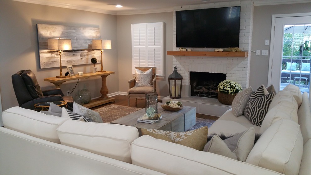 Inspiration for a medium sized traditional open plan living room in Little Rock with beige walls, dark hardwood flooring, a standard fireplace, a brick fireplace surround, a wall mounted tv and brown floors.